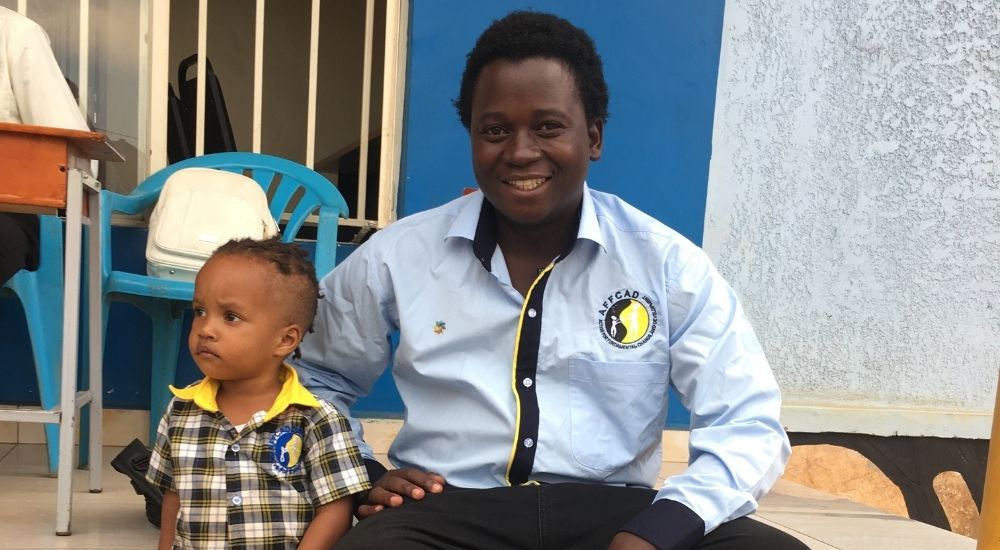 Nyombi Tazan Jaffar, AFFCAD Co-Founder, with child