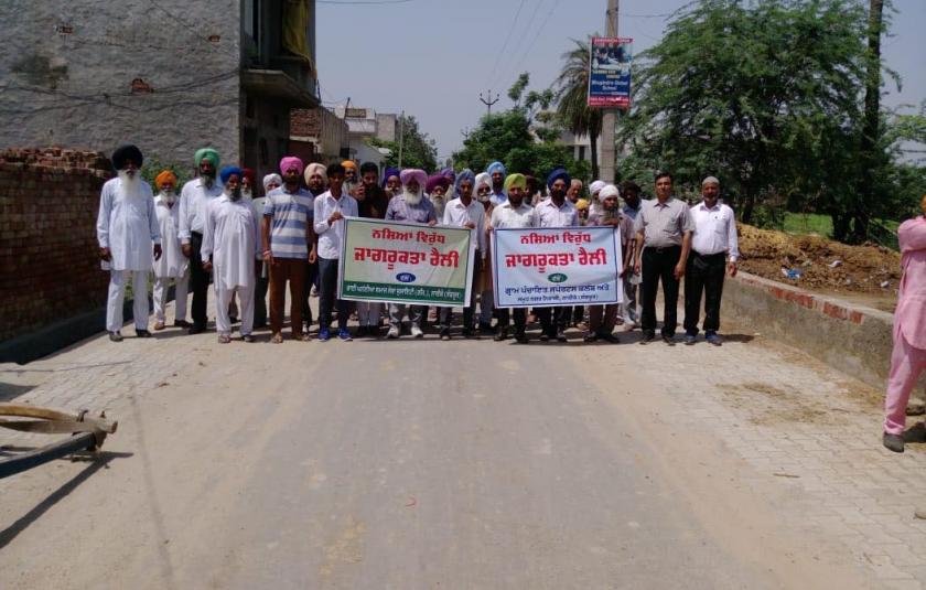 A group of Punjabi men running in a marathon with banners in their hand.