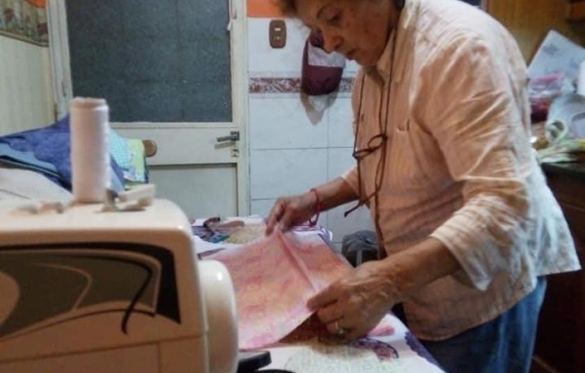 Photo: Old woman sewing face mask
