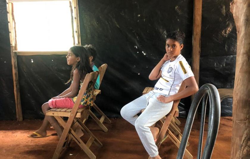 Photo: children sitting on the couch that become school for some ours 