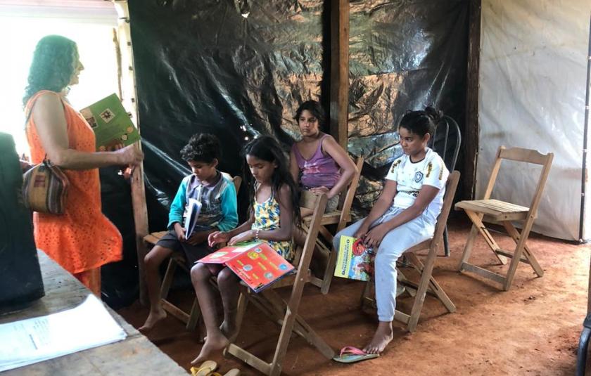 Photo: Teacher Maria Oliva helping the children with their homework. 