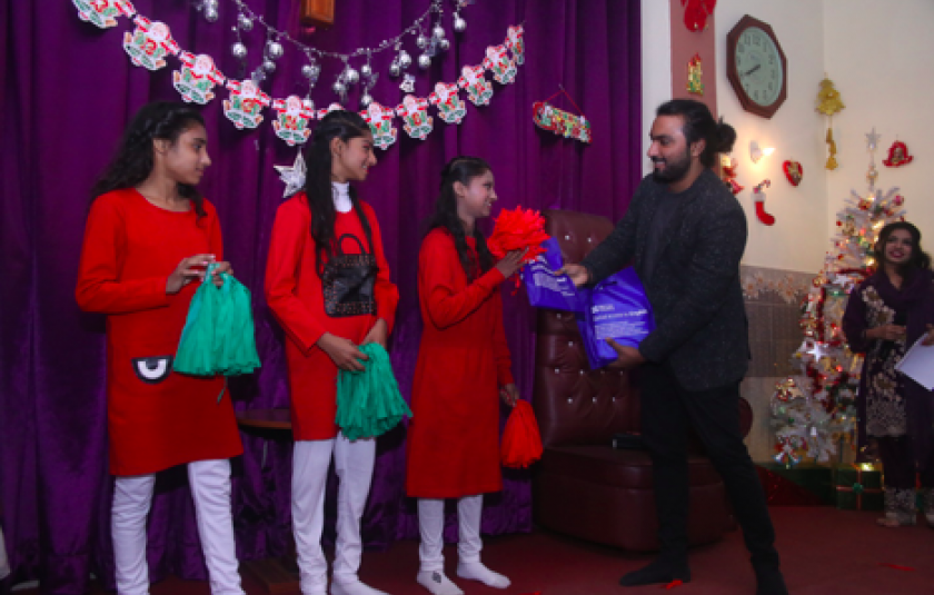 Photo: Man handing gifts to children