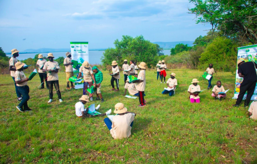 Picture: Children sit spread out across the grass reading books 