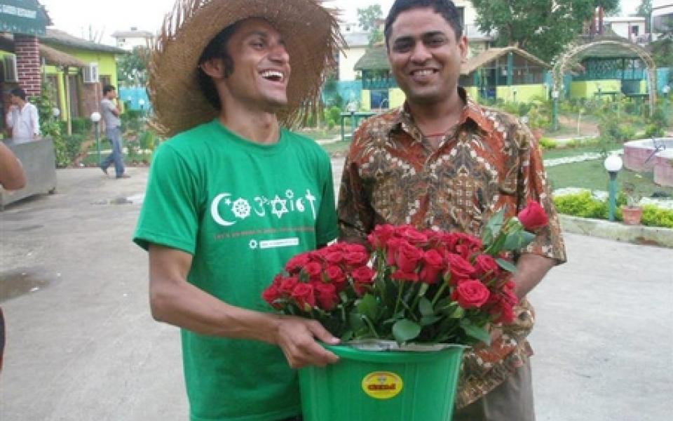 A man holding a bowl of flower and smiling