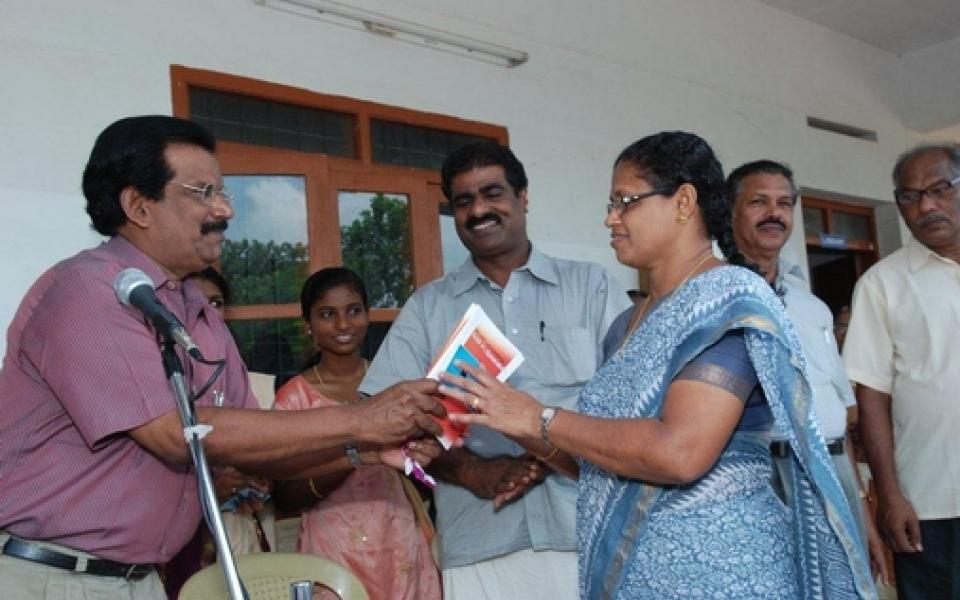 A man giving a book to a woman 