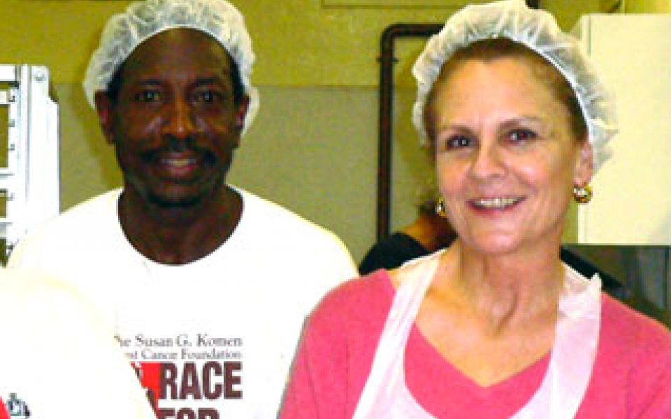 a photo of a black man and white lady helping homeless people