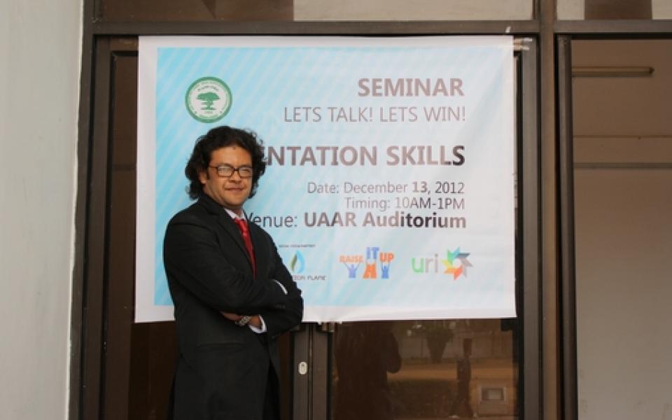 A man is standing in front of a poster 