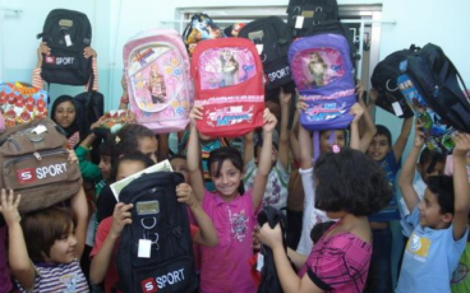 young children are holding their pack back Ramadan gifts