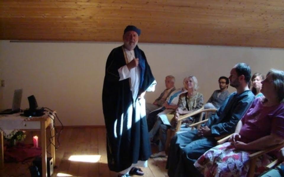 An old man speaking to a crowd of people 