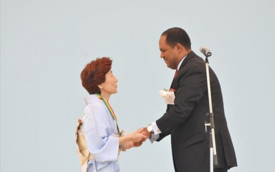 Mussie Hailu, shaking hand with a women in japan
