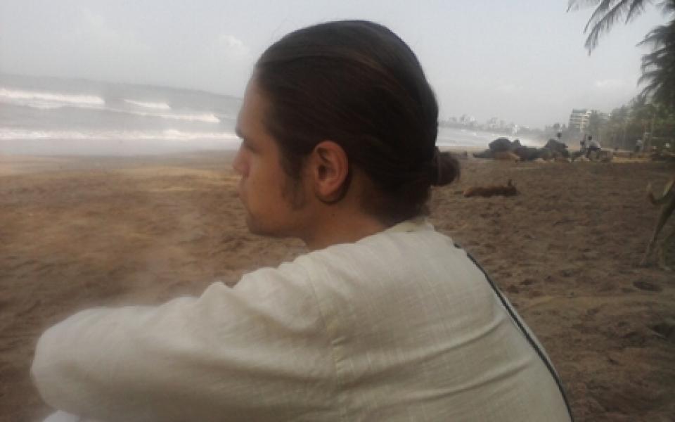 A man watching the sea, while seating down 