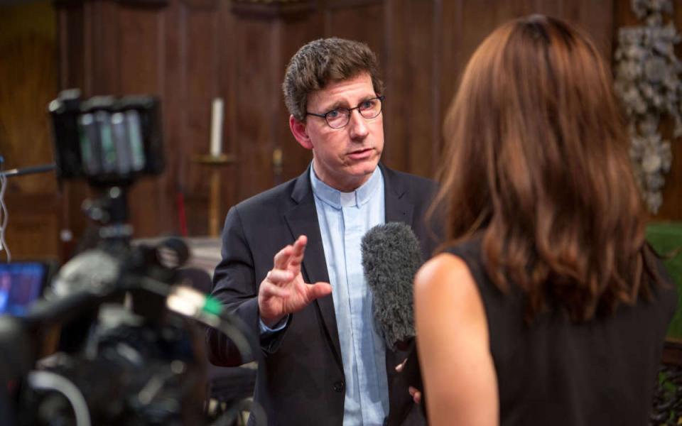 Photo of a man speaking into a microphone