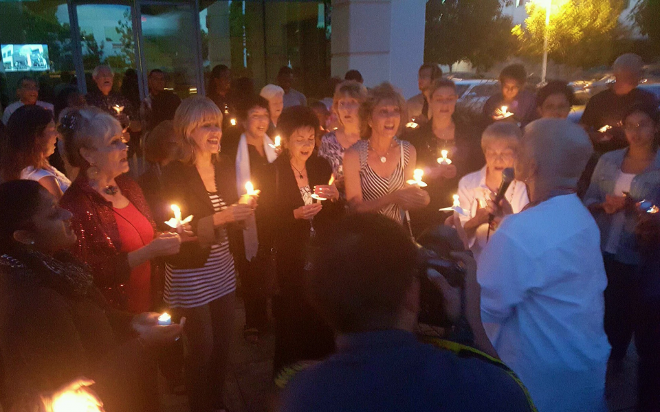 Women stand in a circle holding candles. 