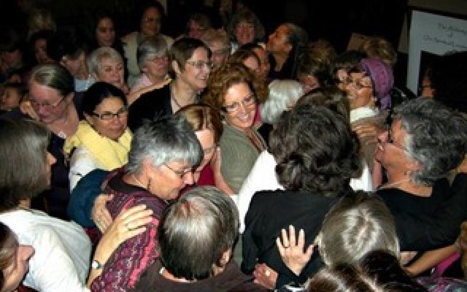 A group of women hugging in a circle.