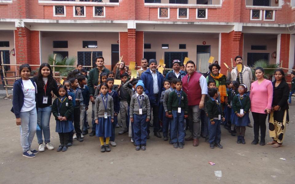 A group of children posing for a photo in front of a building.