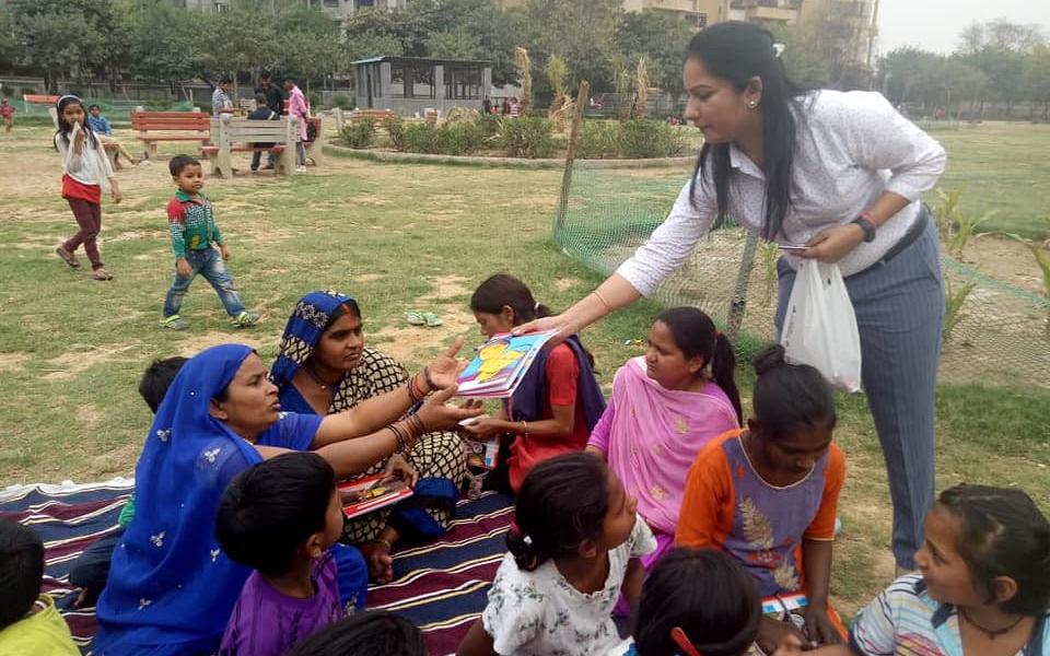 A woman handing out stationery to women and children.