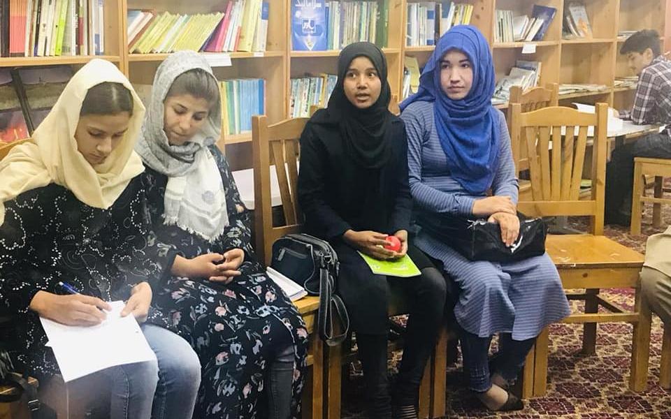 A group of Afghan girls sitting on chairs.