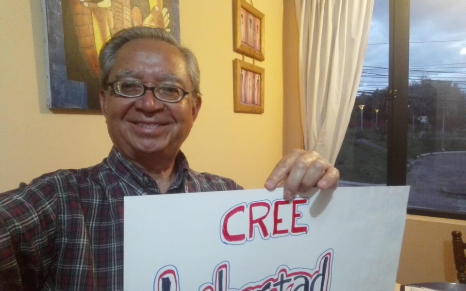 Photo: Victor holding on his hands a sign saying Freedom