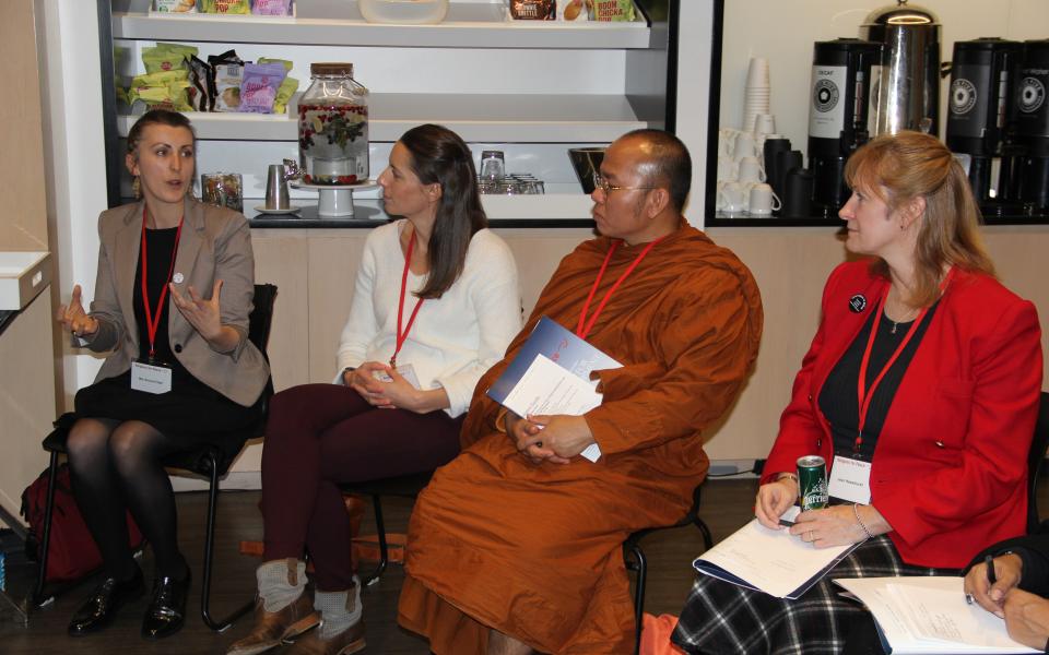 Photo: four people sitting in a row in dialogue