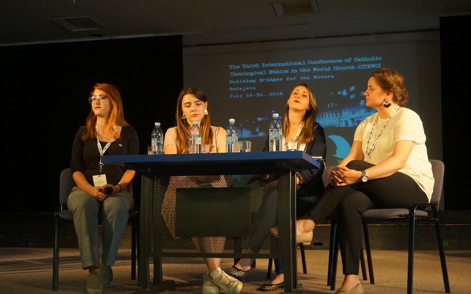 Photograph: Four women sitting behind a table speaking at a conference