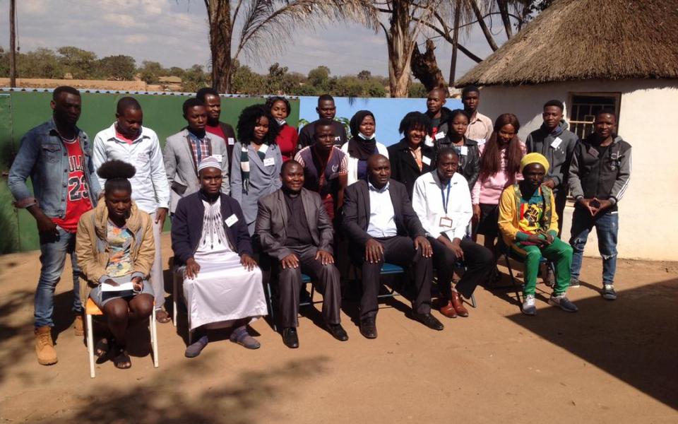 Photo: Group photo of about 20 people, one row sitting and one row standing. Participants of the Malawi youth interfaith training programme